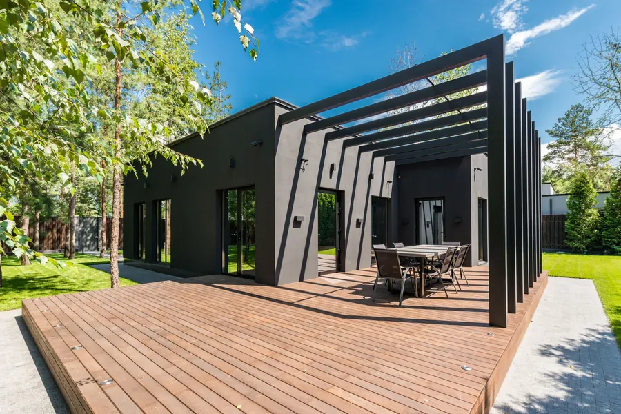 Modern composite deck with dark pergola and outdoor dining area — Lake Tapps, WA