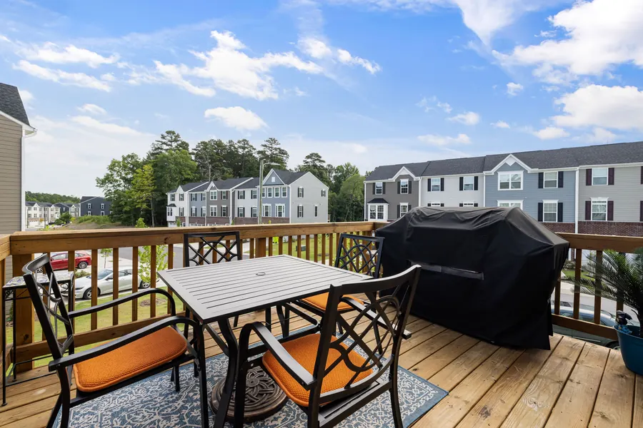 Deck railing on a raised balcony with siding-clad homes in background